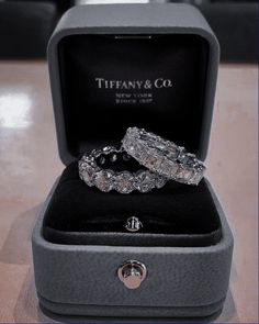 two wedding rings sitting in a box on top of a table