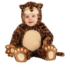 a baby in a leopard costume sitting on the ground with its paws up and eyes closed