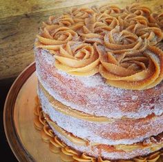 a three layer cake covered in powdered sugar and topped with icing spirals