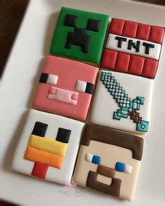 four decorated cookies sitting on top of a white plate