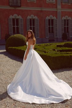 a woman in a wedding dress standing outside