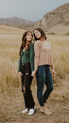 two women standing in a field holding hands