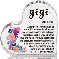 a heart shaped plaque with the words gigi written in english and floral designs on it