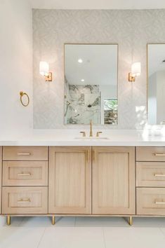 a bathroom with double sinks and two mirrors on the wall next to eachother