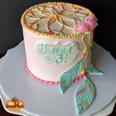 a birthday cake that is decorated with flowers and leaves on a white plate in front of a black background