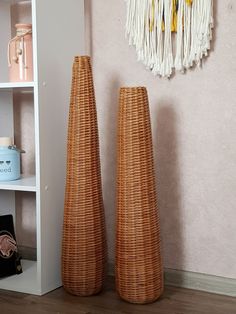 two wicker vases sitting next to each other in front of a white shelf