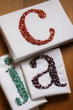 three napkins with beaded letters on them