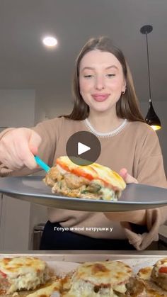 a woman holding a plate with food on it