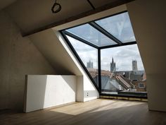 an empty room with a large window overlooking the cityscape and cathedrals in the distance