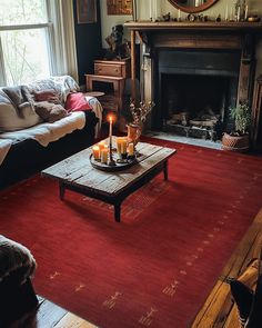 a living room filled with furniture and a fire place in front of a mirror on the wall