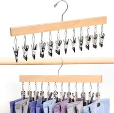 several pairs of scissors hanging from hooks on a wooden hanger