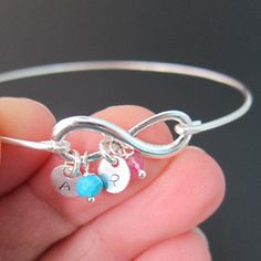 "Mother's Infinity Bracelet with Initials and/or either Birthstones or Simulated Birthstone Months Depending on the Month 1) January - Garnet 2) February - Amethyst 3) March - Aquamarine 4) April - Clear Aquamarine to Simulate Diamond 5) May - Emerald 6) June - Cultured Freshwater Pearl 7) July - Ruby 8) August - Peridot 9) September - Lapis Lazuli to Simulate Sapphire 10) October - Pink Quartz to Simulate Pink Tourmaline 11) November - Citrine 12) December - Turquoise Select 1 to 4 initials and Bangle For Mother's Day Birthday Gift, Mother's Day Birthday Bangle Jewelry Gift, Mother's Day Birthday Gift Bangle Jewelry, Adjustable Sterling Silver Bracelets For Birthday Gift, Adjustable Infinity Jewelry For Mother's Day, Friendship Birthstone Bracelets For Mother's Day, Mother's Day Friendship Bracelet With Birthstone, Birthstone Jewelry For Friendship On Mother's Day, Adjustable Infinity Jewelry For Birthdays