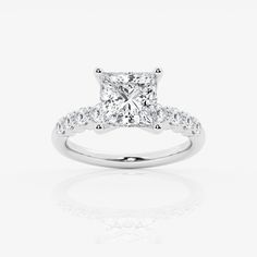 a princess cut diamond engagement ring with three stones on the band and shoulders, set in 18k white gold