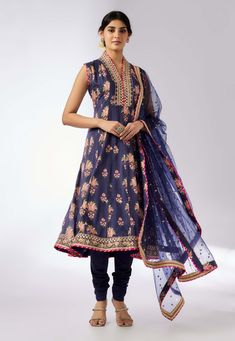 This enchanting ensemble features a floral print with intricate border embroidery. The anarkali kurta, paired with a matching dupatta adorned in sequins and gold thread, exudes elegance and charm. The plain churidar complements the set, adding a touch of feminine grace and sophistication. Perfect for any special occasion. Party Wear Suit Design, Anarkali Suits For Wedding, Party Wear Anarkali Suits, White Anarkali Suits, Suit Patiala, Dresses Punjabi, Navy Blue Kurta, Wedding Anarkali, Mens Party Wear