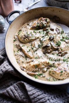 a pan filled with chicken and mushrooms covered in gravy on top of a table