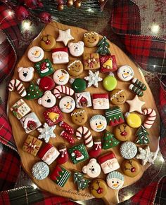 christmas cookies are arranged on a wooden platter