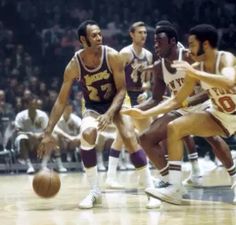 the basketball players are trying to block the ball from being guarded by two opposing opponents