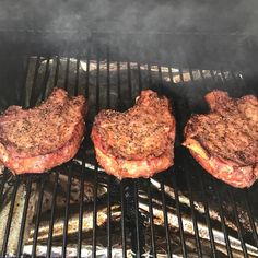 three steaks cooking on top of a grill