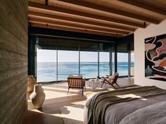 a bedroom with a large window overlooking the ocean