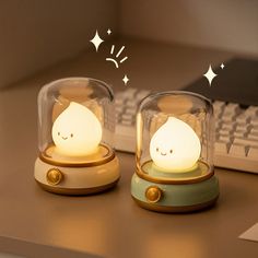 two little lamps sitting on top of a desk