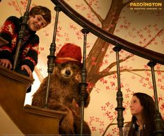 two girls and a bear are standing on the stairs