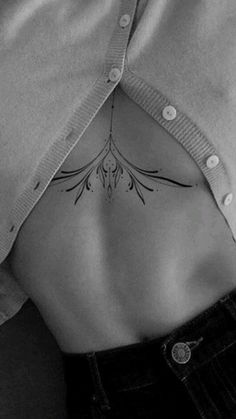 a woman's stomach with a flower tattoo on her lower back and the bottom part of her body