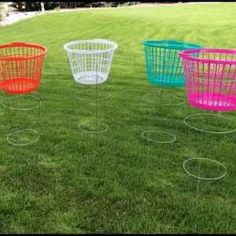 four different colored baskets sitting in the grass