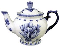 a blue and white teapot with flowers on it's side, sitting in front of a black background