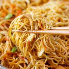 chopsticks sticking out of noodles in a bowl