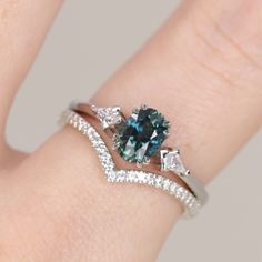 a woman's hand with a ring on it and a blue stone in the middle