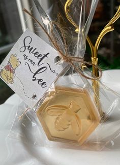 a honey jar filled with sweet treats on top of a white tablecloth covered table