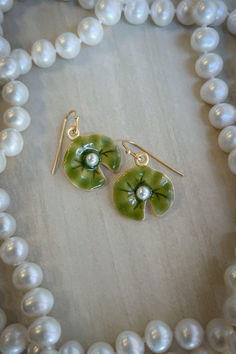 These dangle earrings represent the artistic legacy of Monet with these beautifully detailed green enamel lily pads set with a white faux pearl in the center. Lily Pad Earrings, Crystal Accessories, Creating Jewelry, Green Enamel, Water Lily, Gift Store, Toe Rings, Lily Pads, Stone Bracelet