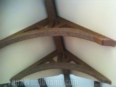 three wooden crosses hanging from the ceiling in a room with white walls and wood beams