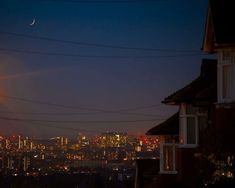 the city skyline is lit up at night, with power lines running across the foreground