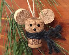 a cork mouse ornament hanging from a pine tree