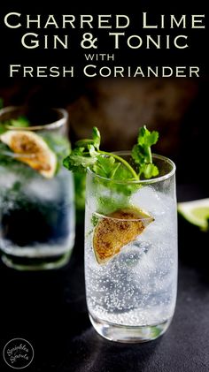 two glasses filled with gin and tonic on top of a black table next to limes