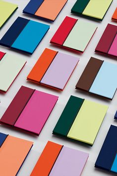 many different colors of paper are arranged on a white surface with one color in the middle