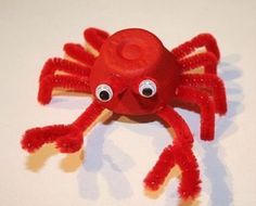 a red crab made out of toilet paper with googly eyes