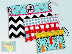 three zippered pouchs with different patterns and designs on them, one has a measuring tape