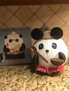 a paper mache with a panda face on it sitting next to a book about what's in panda