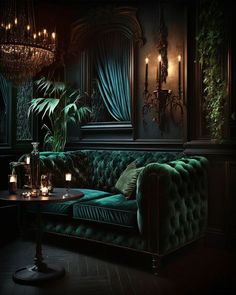 a green velvet couch in a dark room with candles on the table and chandeliers hanging from the ceiling