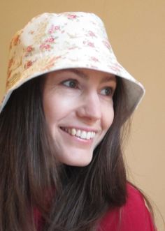 a woman wearing a hat and smiling for the camera