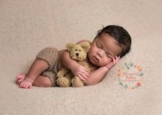 a baby is sleeping with a teddy bear