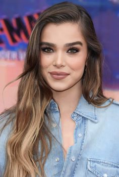 an image of a woman with long hair wearing denim shirt and jeans on the red carpet