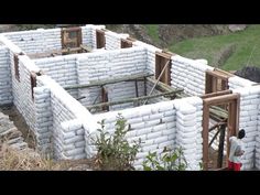 a man standing in front of a building made out of cinder blocks