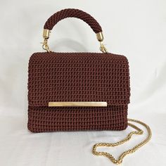 This elegant hand-knit bag is perfect for everyday use. Crafted with macramé cord, it boasts gold accessories and a lining that accentuates its chic appeal. With crochet details and a chain strap, this bag, measuring 22cm (8,66 inç )x17 cm (6,69 inç)x 8 cm (3,15 inç)e is both practical and stylish. SEND A MESSAGE FOR A CUSTOMIZED BAG SHIPPING AND RETURNS: * Free shipping * Ready to ship within 3-6 business days * 30-day return policy Brown Crochet Bag Gift, Brown Crochet Bag For Gift, Brown Hand-knitted Rectangular Bag, Handwoven Crochet Shoulder Bag Gift, Brown Crochet Bag With Braided Handles, Crochet Bag With Detachable Handle For Daily Use, Daily Use Crochet Bag With Detachable Handle, Everyday Handwoven Crochet Bag With Top Handle, Brown Rectangular Crochet Bag With Braided Handles