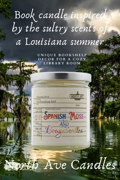 a candle with the words spanish moss and bonsainita on it in front of water