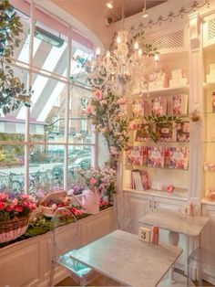 a room filled with lots of flowers and plants next to a large window sill