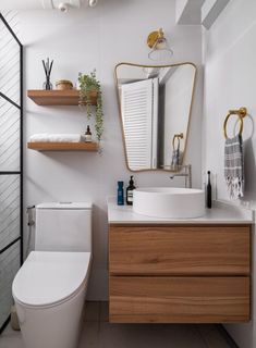 a bathroom with a toilet, sink and shelves on the wall next to each other