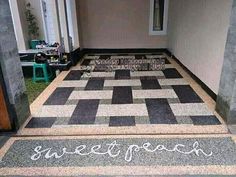 the words sweet peace are written in chalk on an entrance mat that is decorated with black and white checkered squares